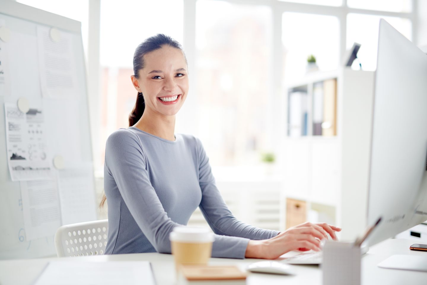 Woman smiling while typing on computer